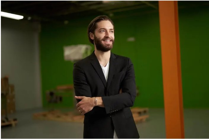 Brian Larsen in a black blazer, arms crossed, standing in the production facility